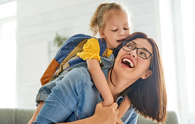 Happy woman with small child on her back.
