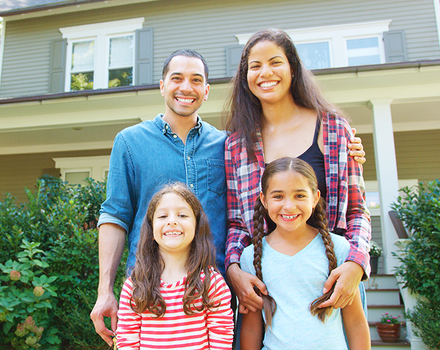 Family standing in front of home.