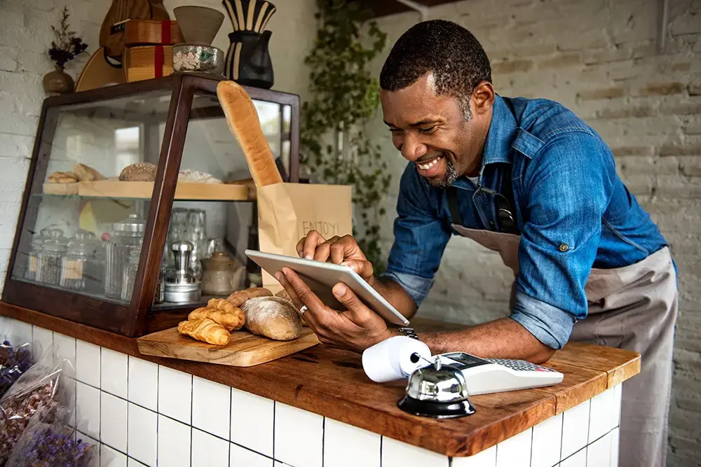 Man in a bakery working on a digital tablet.